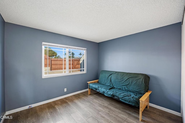 living area with a textured ceiling and hardwood / wood-style flooring