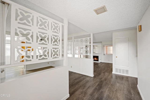 interior space featuring a textured ceiling and dark hardwood / wood-style flooring