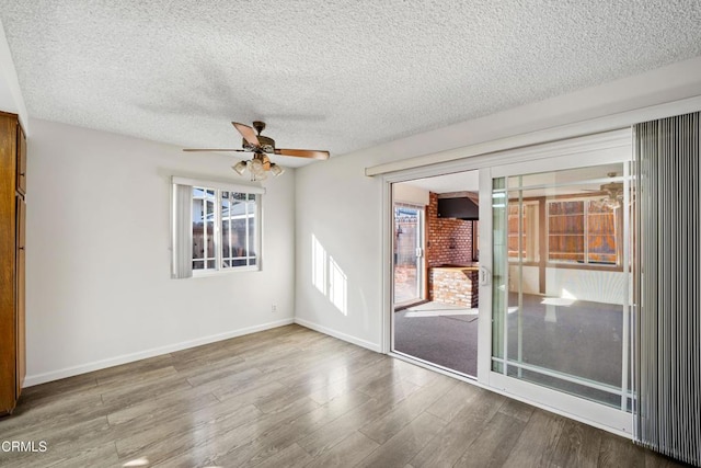 unfurnished room featuring ceiling fan, wood-type flooring, and a textured ceiling