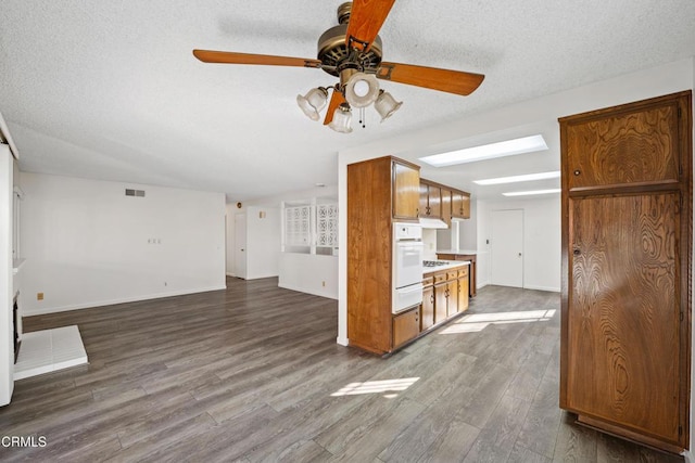 unfurnished living room with ceiling fan, a textured ceiling, and hardwood / wood-style floors