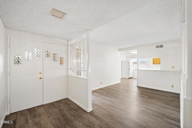 entryway with dark wood-type flooring and a textured ceiling