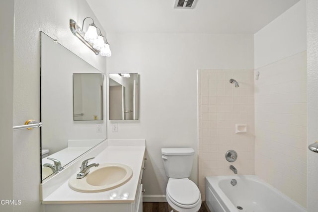 full bathroom featuring toilet, tiled shower / bath, and vanity