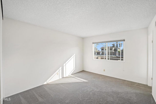 carpeted spare room featuring a textured ceiling