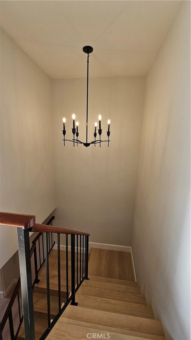 staircase with a notable chandelier