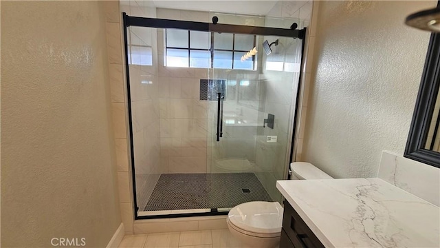 bathroom with walk in shower, vanity, toilet, and tile patterned flooring