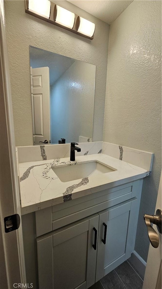 bathroom featuring vanity, tile patterned floors, and a textured ceiling