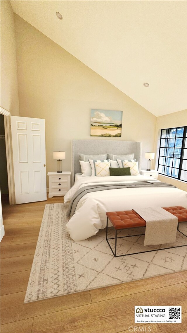 bedroom featuring wood-type flooring and high vaulted ceiling