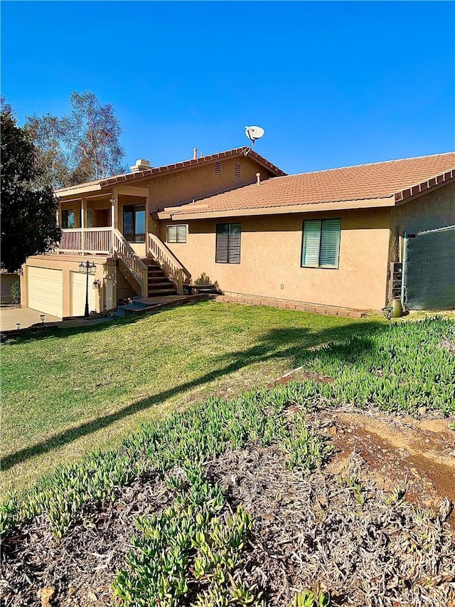 rear view of property with a yard and a garage