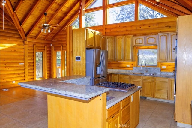 kitchen with rustic walls, appliances with stainless steel finishes, sink, and high vaulted ceiling