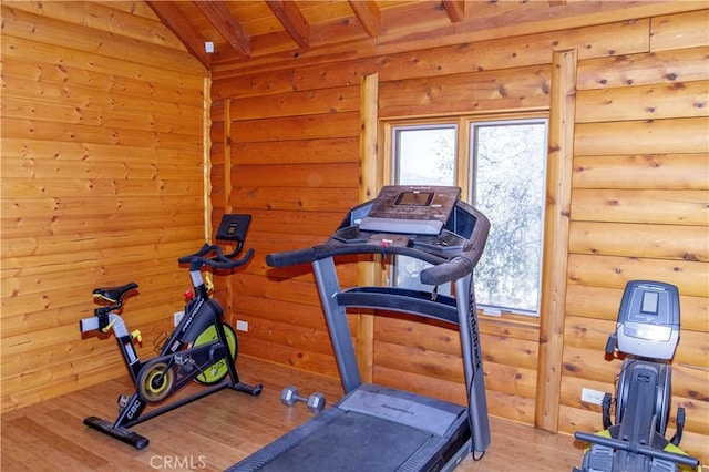 exercise area with lofted ceiling, wood ceiling, hardwood / wood-style flooring, and log walls