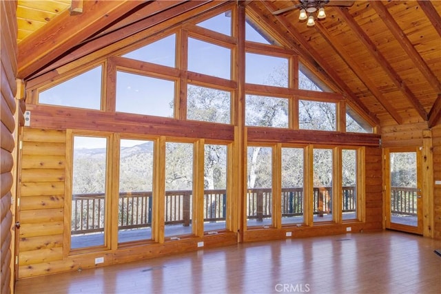 interior space featuring ceiling fan, lofted ceiling with beams, and wood ceiling