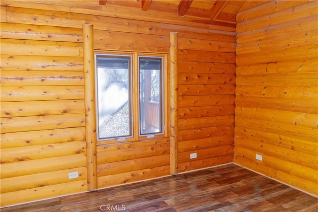 unfurnished room featuring rustic walls, dark hardwood / wood-style floors, and lofted ceiling with beams