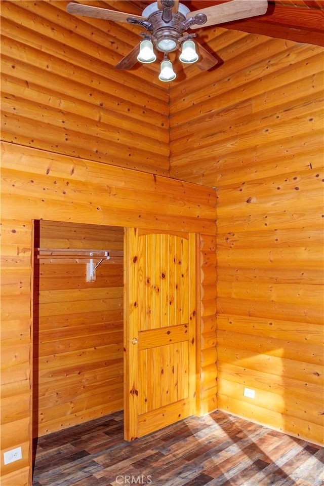 empty room with wood-type flooring and rustic walls