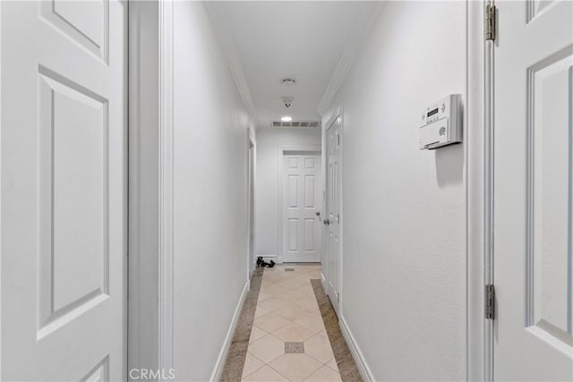 hall featuring light tile patterned floors and ornamental molding