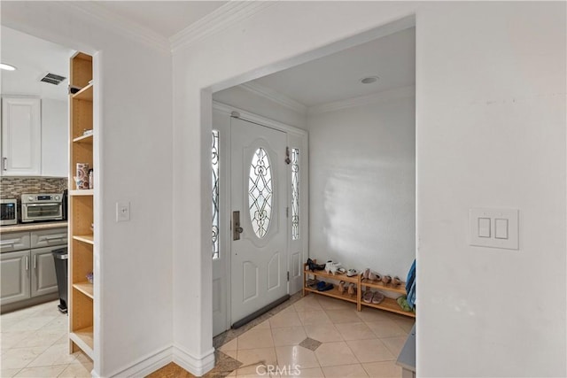 entrance foyer with light tile patterned floors and crown molding