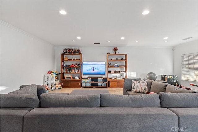 living room with wood-type flooring and ornamental molding