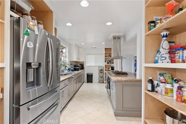 kitchen with light stone countertops, sink, ventilation hood, white cabinets, and appliances with stainless steel finishes