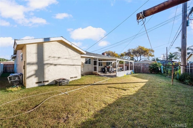 back of house featuring a patio area and a yard