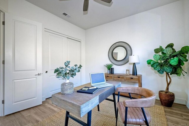 home office featuring ceiling fan and light hardwood / wood-style flooring