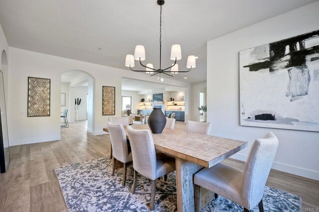 dining space with a notable chandelier and light hardwood / wood-style flooring