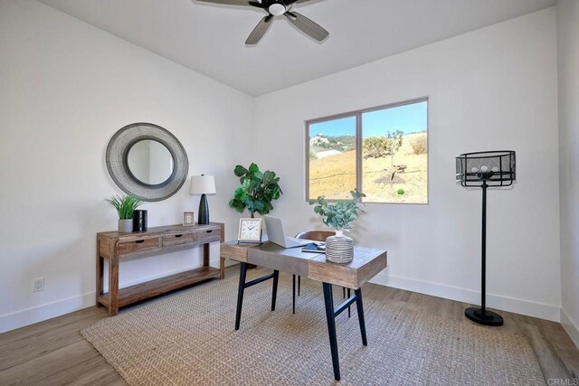 home office with ceiling fan and light hardwood / wood-style floors