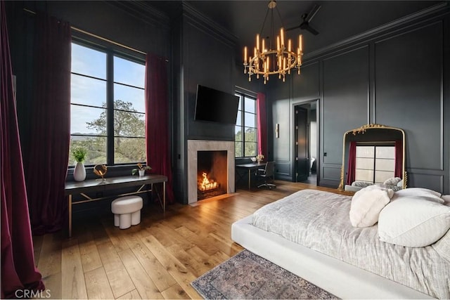 bedroom featuring wood-type flooring, crown molding, and multiple windows