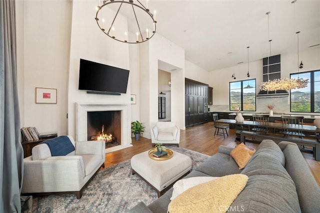 living room with hardwood / wood-style flooring, a high ceiling, and a notable chandelier