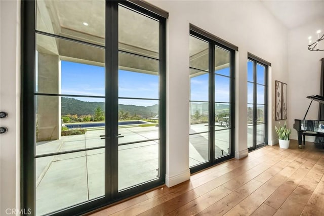 doorway featuring french doors, a notable chandelier, a mountain view, and hardwood / wood-style floors