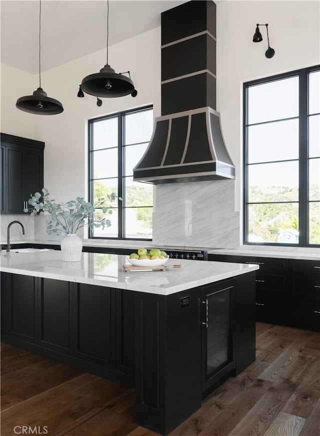 kitchen featuring light stone countertops, decorative backsplash, dark hardwood / wood-style floors, and sink