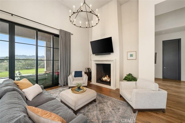 living room with a chandelier, hardwood / wood-style floors, and a towering ceiling