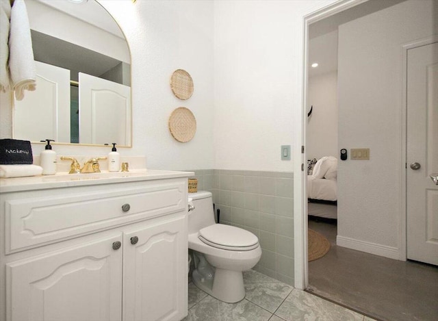 bathroom featuring tile walls, toilet, and vanity