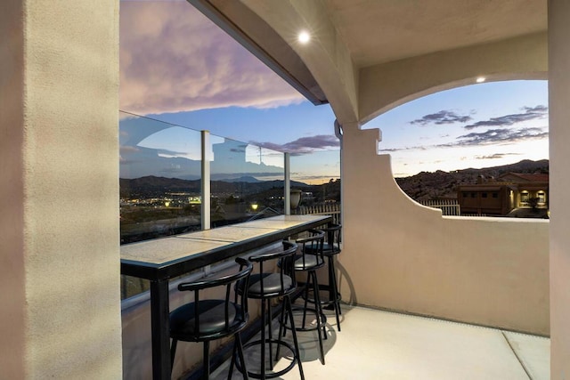 balcony at dusk featuring a mountain view