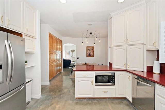 kitchen with white cabinets, kitchen peninsula, concrete floors, and stainless steel appliances