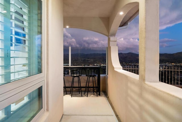 balcony at dusk featuring a mountain view