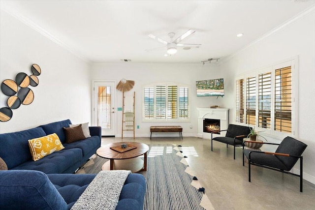 living room with ceiling fan, plenty of natural light, and ornamental molding