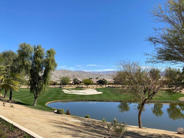 view of home's community featuring a water and mountain view and a yard