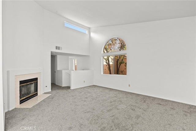 unfurnished living room featuring a healthy amount of sunlight, light colored carpet, and a high ceiling