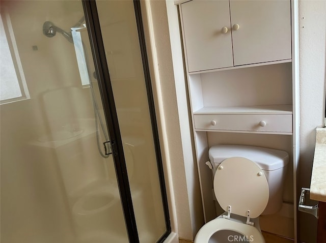 bathroom featuring an enclosed shower and toilet