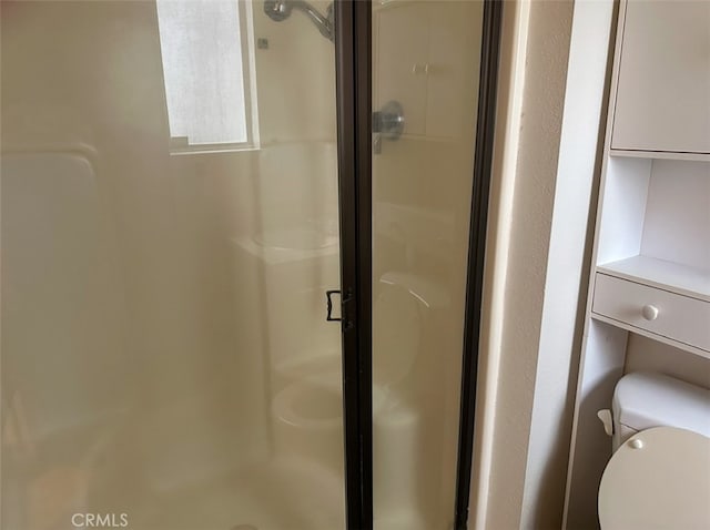 bathroom featuring an enclosed shower and toilet