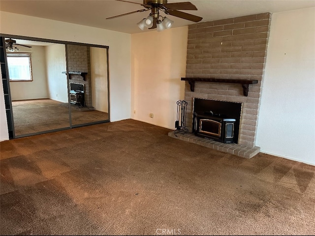 unfurnished living room featuring carpet, ceiling fan, and a wood stove