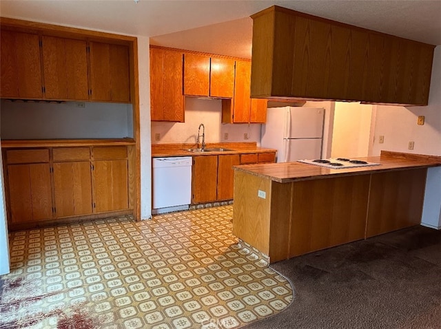 kitchen with sink, kitchen peninsula, and white appliances