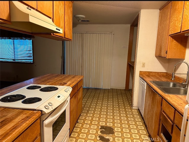 kitchen featuring sink, wooden counters, and white appliances