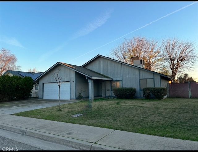 view of front of house with a lawn, central AC unit, and a garage