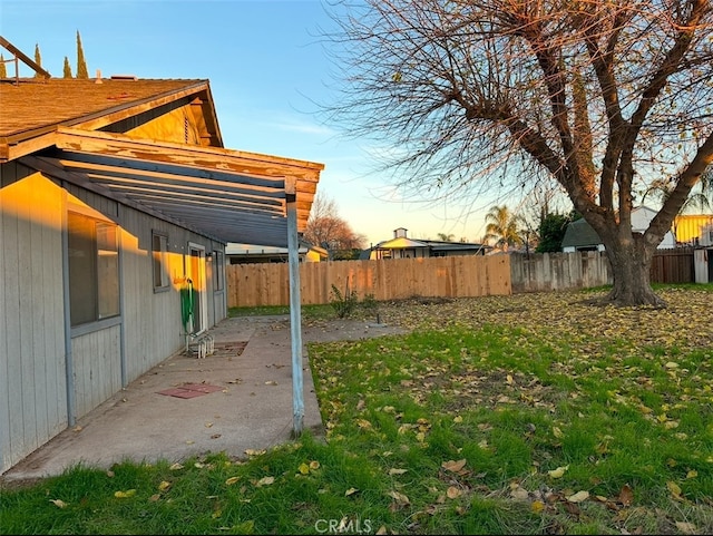 yard at dusk featuring a patio