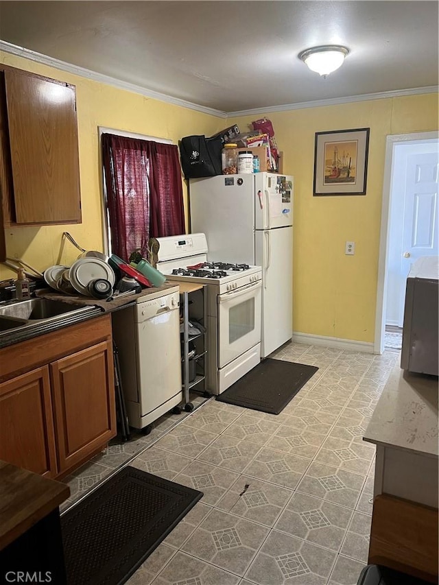 kitchen featuring sink, white appliances, and crown molding