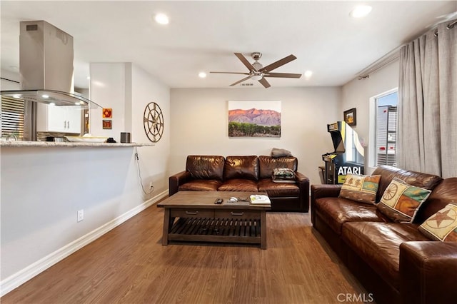 living room featuring ceiling fan and dark hardwood / wood-style flooring