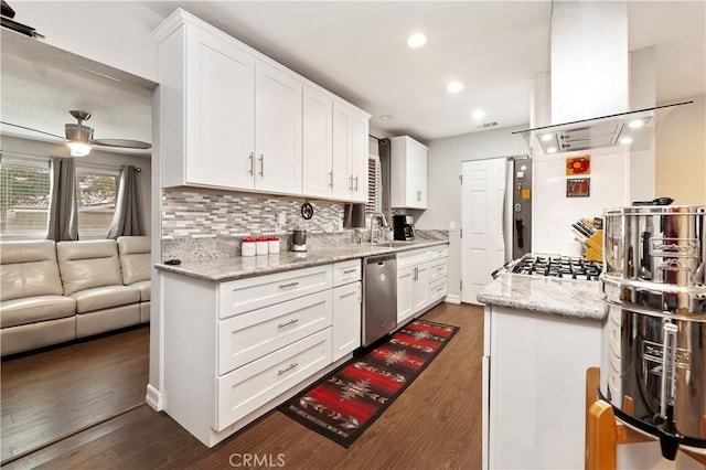 kitchen featuring appliances with stainless steel finishes, white cabinetry, island range hood, and light stone countertops