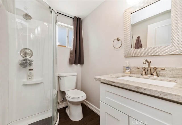 bathroom featuring toilet, a shower with shower door, hardwood / wood-style floors, and vanity