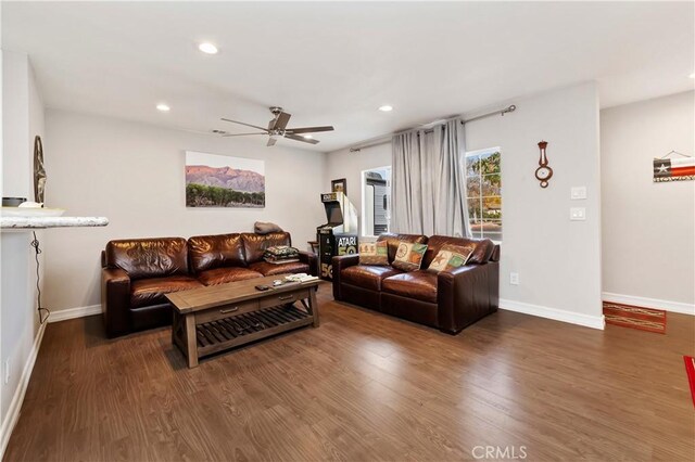 living room featuring ceiling fan and dark hardwood / wood-style flooring