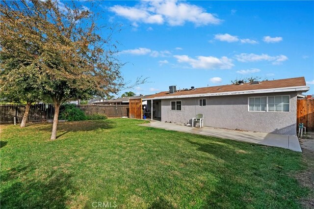 back of house featuring a lawn and a patio area